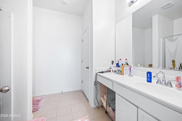 bathroom with tile patterned flooring, vanity, and walk in shower