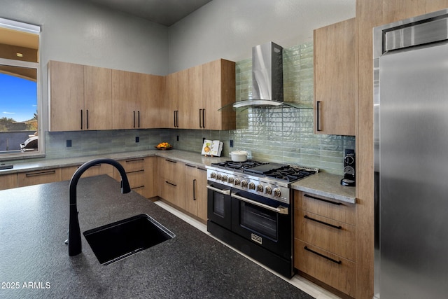 kitchen with stainless steel fridge, sink, decorative backsplash, wall chimney range hood, and double oven range