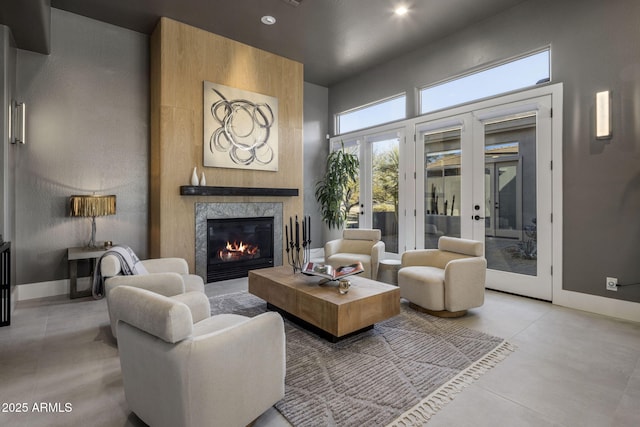 living room with french doors, a high ceiling, and a fireplace