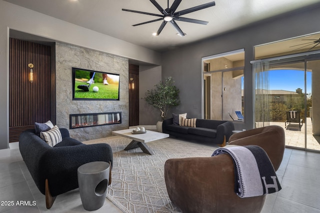 living room with a large fireplace and ceiling fan