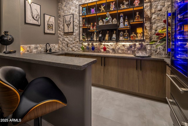 bar with sink and dark brown cabinetry