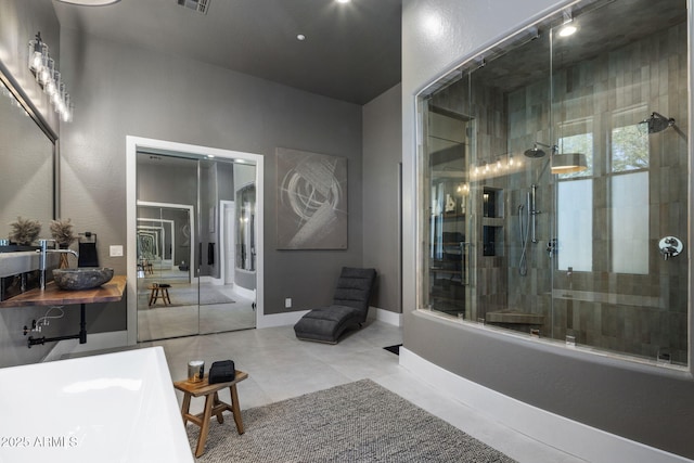 bathroom featuring vanity, tiled shower, and tile patterned floors