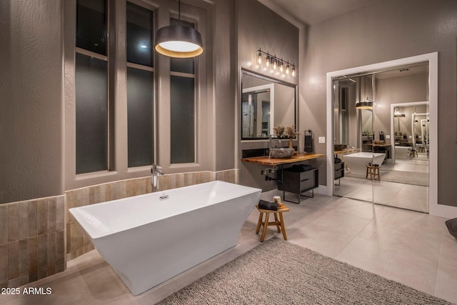 bathroom featuring a tub, tile walls, and tile patterned flooring