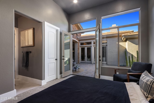 unfurnished bedroom featuring light carpet and french doors