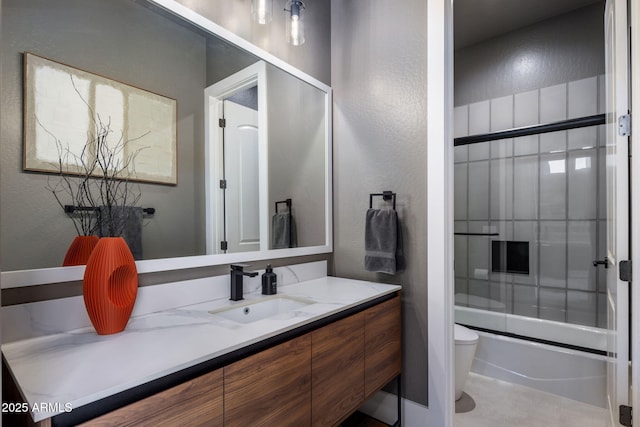 full bathroom featuring combined bath / shower with glass door, vanity, and toilet