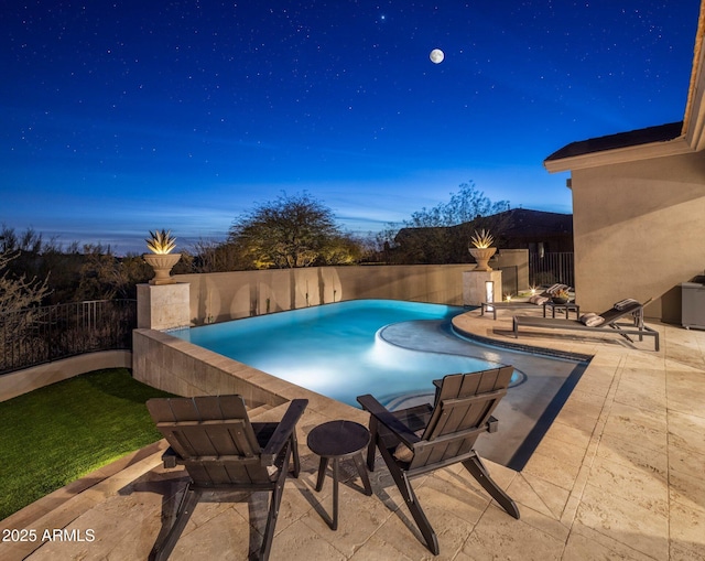 pool at dusk with a patio area