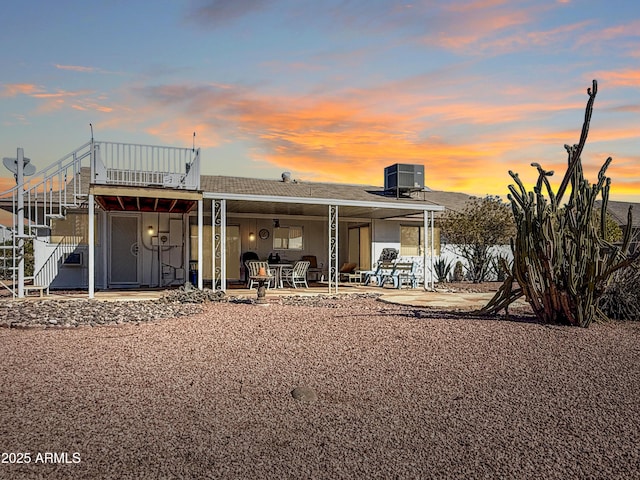 rear view of property featuring a patio area, fence, and stairs