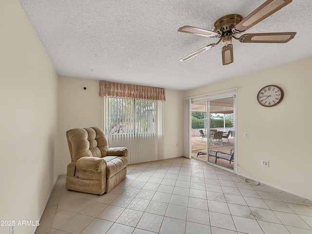 sitting room with light tile patterned floors, ceiling fan, a textured ceiling, and a wealth of natural light