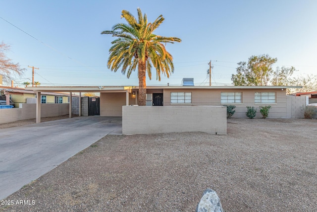 ranch-style home featuring fence and an attached carport