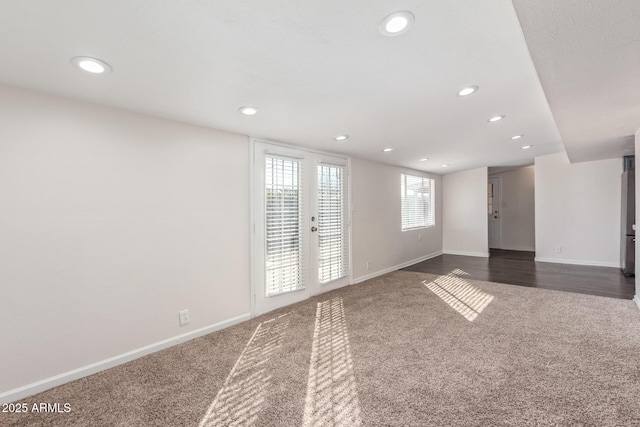 empty room with baseboards, dark colored carpet, and recessed lighting