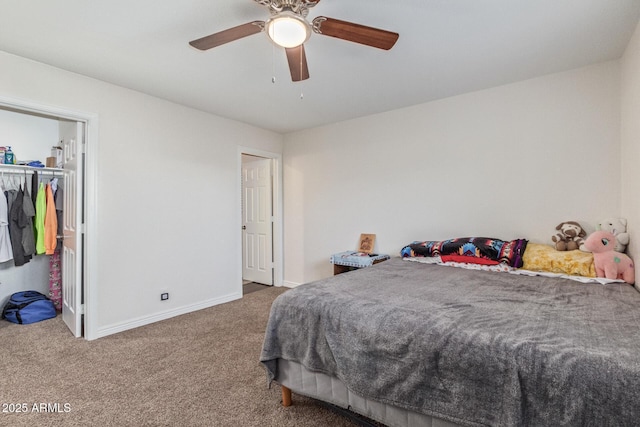 bedroom featuring a walk in closet, carpet, baseboards, and ceiling fan