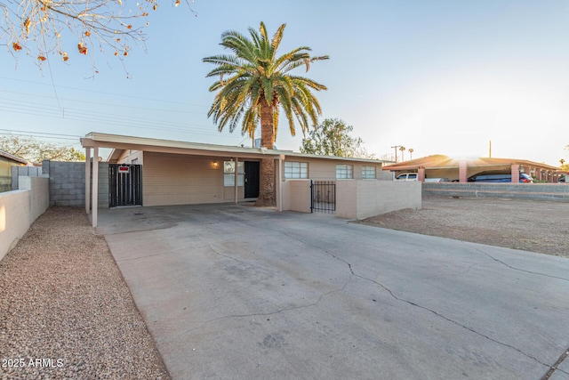 view of front of property with a fenced front yard, a gate, and a carport