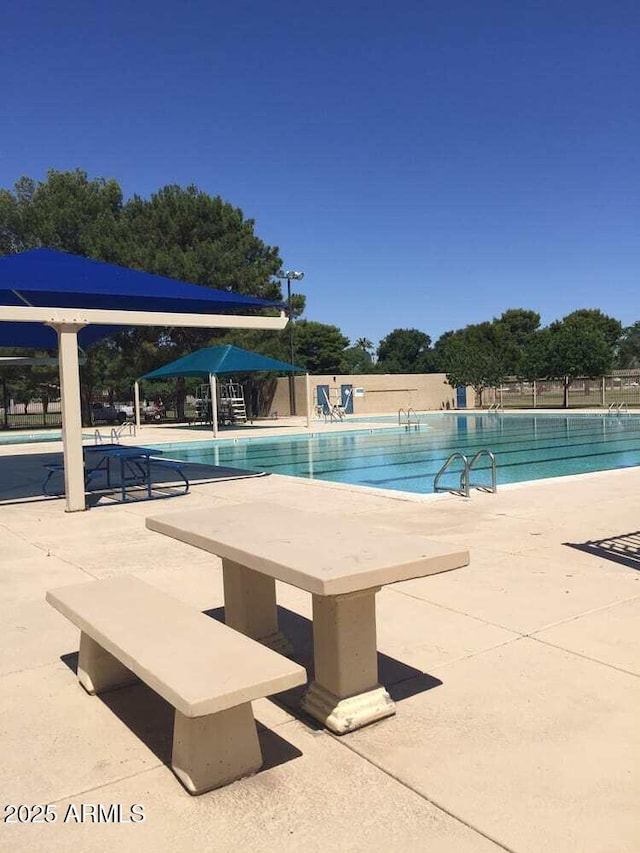 pool with a patio and fence