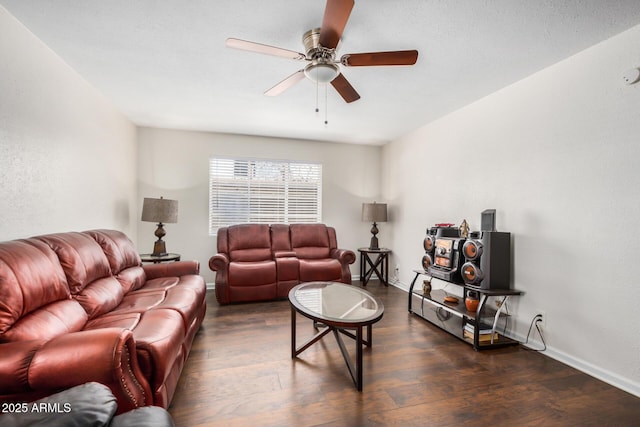 living room with dark wood-type flooring, ceiling fan, and baseboards