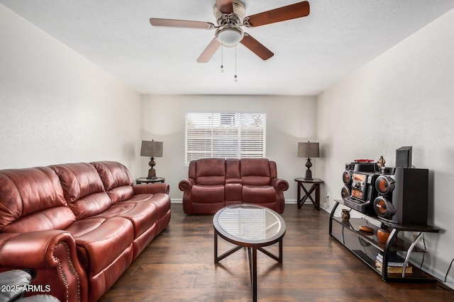 living area featuring dark wood-style floors, baseboards, and a ceiling fan