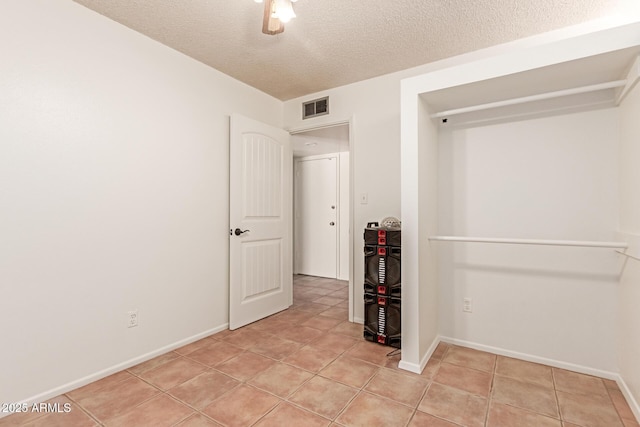 unfurnished bedroom featuring light tile patterned floors and a textured ceiling