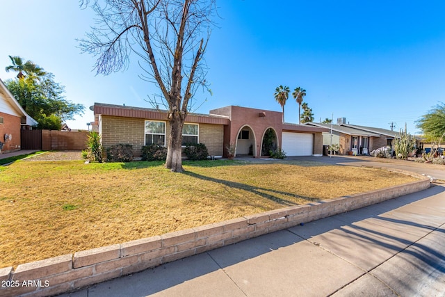 ranch-style house with a garage and a front lawn