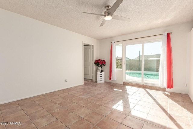 spare room with ceiling fan, a textured ceiling, and light tile patterned flooring