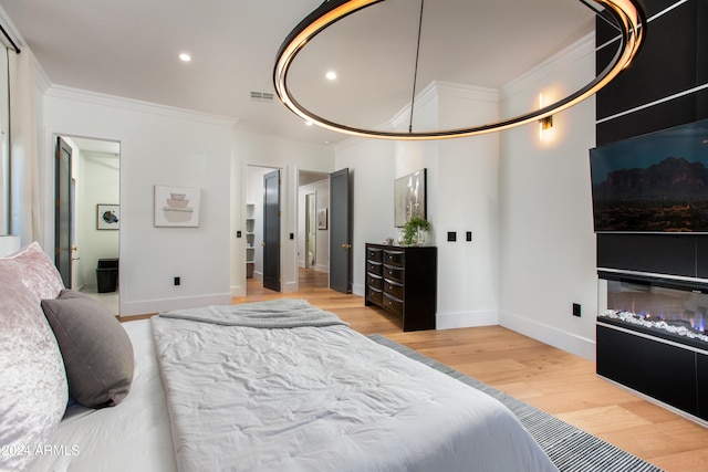 bedroom with crown molding and light hardwood / wood-style flooring