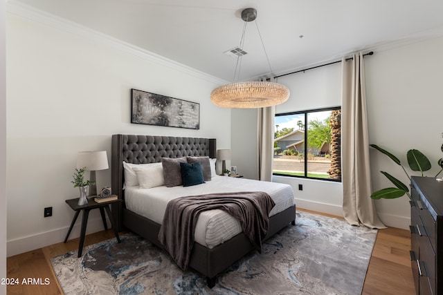 bedroom with ornamental molding and dark wood-type flooring