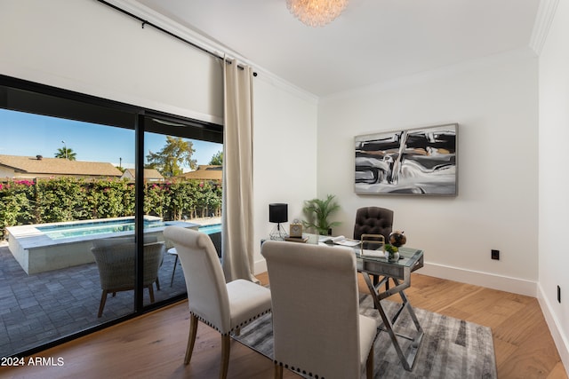 dining space with hardwood / wood-style flooring and crown molding