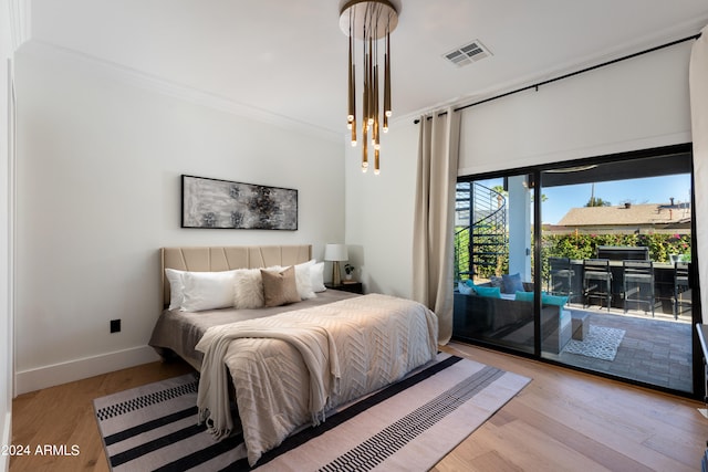 bedroom with access to exterior, ornamental molding, and light wood-type flooring