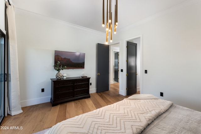 bedroom featuring ornamental molding and light hardwood / wood-style floors