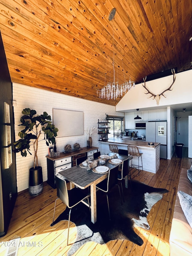 dining area with brick wall, wood ceiling, and dark hardwood / wood-style flooring