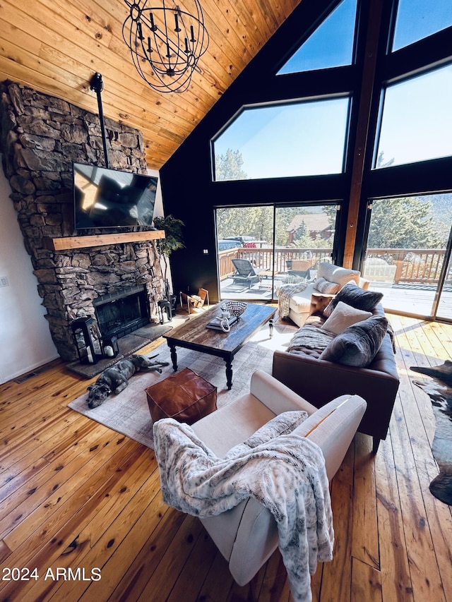 living room featuring a chandelier, a fireplace, light wood-type flooring, high vaulted ceiling, and wood ceiling