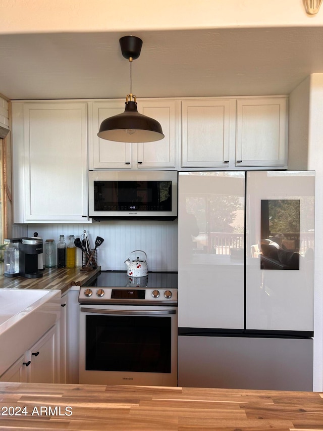 kitchen with white cabinetry, stainless steel appliances, and pendant lighting