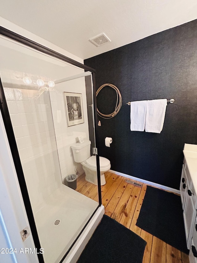 bathroom with vanity, hardwood / wood-style floors, toilet, and walk in shower