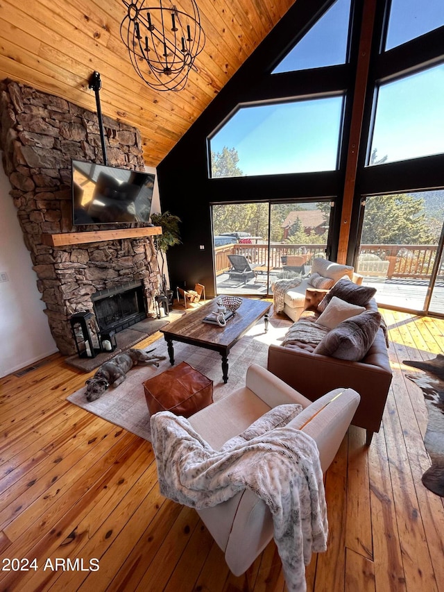 living room with a notable chandelier, high vaulted ceiling, light hardwood / wood-style flooring, wooden ceiling, and a stone fireplace