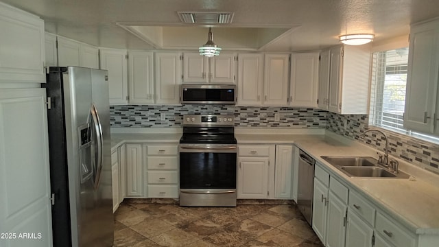 kitchen featuring a raised ceiling, sink, white cabinets, and appliances with stainless steel finishes