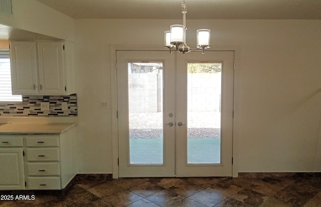 doorway to outside with an inviting chandelier and french doors