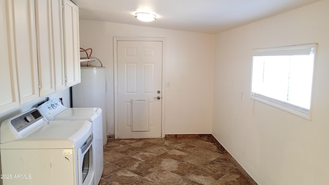 washroom featuring water heater, cabinets, and washing machine and clothes dryer