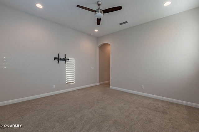 spare room featuring baseboards, visible vents, arched walkways, ceiling fan, and recessed lighting