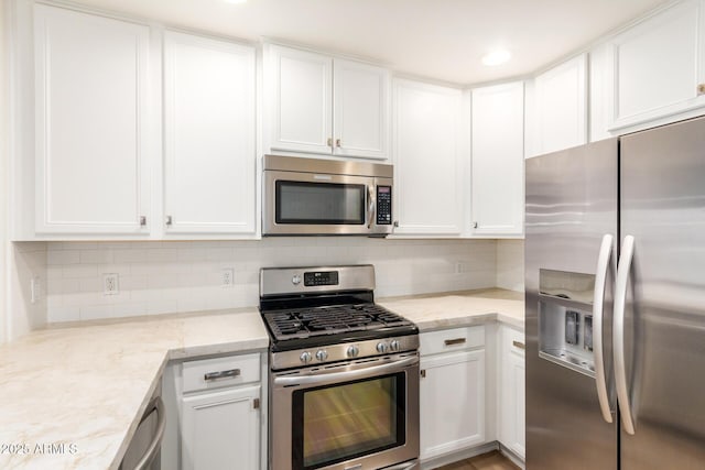 5450 E Deer Valley Dr Unit 1211, Phoenix, AZ 85054 - kitchen with appliances with stainless steel finishes, white cabinets, and decorative backsplash