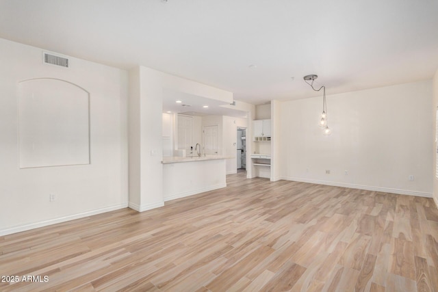 5450 E Deer Valley Dr Unit 1211, Phoenix, AZ 85054 - unfurnished living room featuring light wood finished floors and baseboards