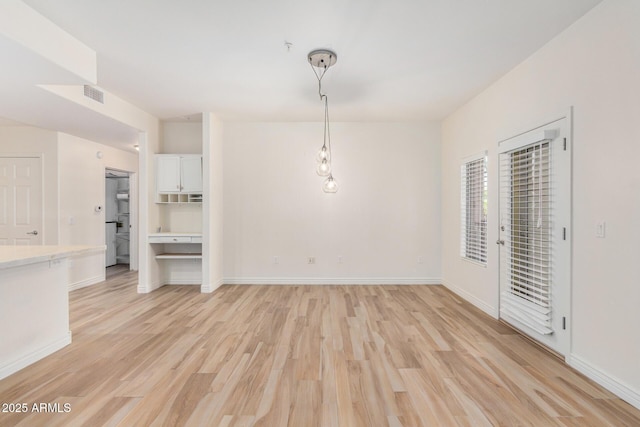 5450 E Deer Valley Dr Unit 1211, Phoenix, AZ 85054 - unfurnished dining area featuring light wood-type flooring and baseboards