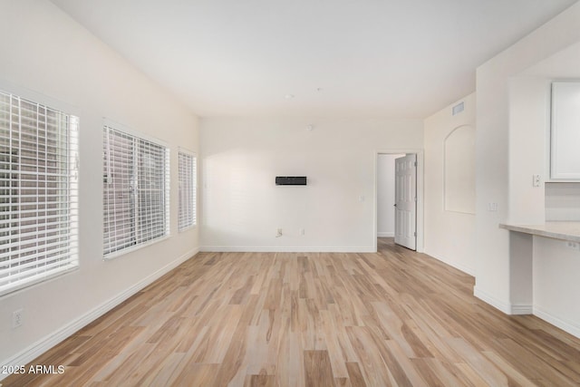 5450 E Deer Valley Dr Unit 1211, Phoenix, AZ 85054 - unfurnished living room featuring light wood-style floors and baseboards