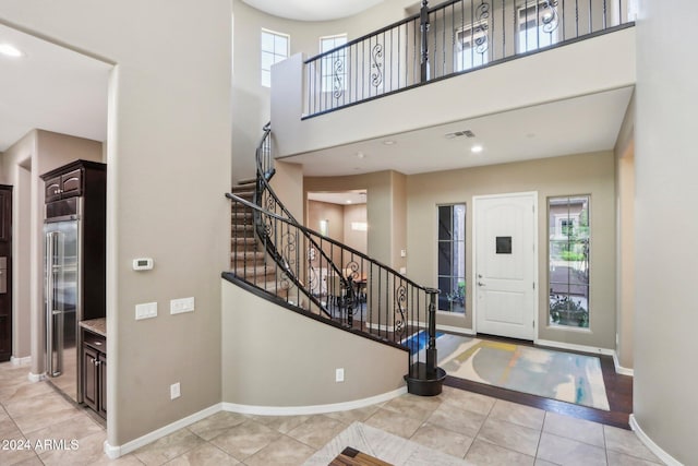 tiled foyer entrance featuring a towering ceiling