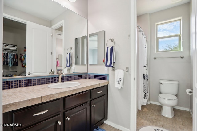 bathroom featuring toilet, a shower with curtain, vanity, and tile patterned flooring