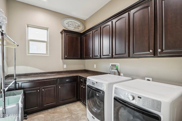 laundry area featuring washer and clothes dryer, cabinets, and light tile patterned floors