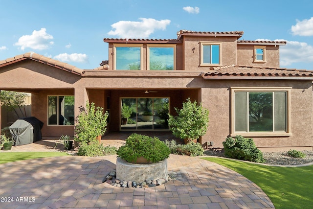 back of house with a lawn and a patio