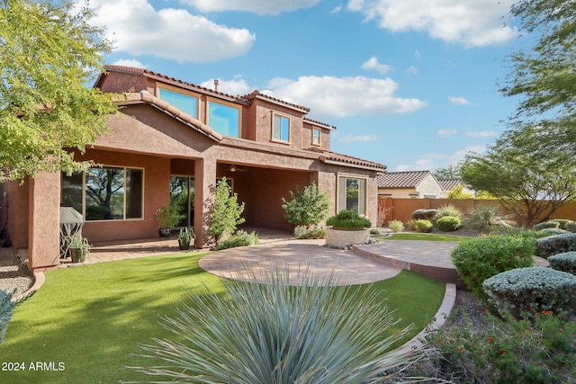 rear view of property with a lawn and a patio area