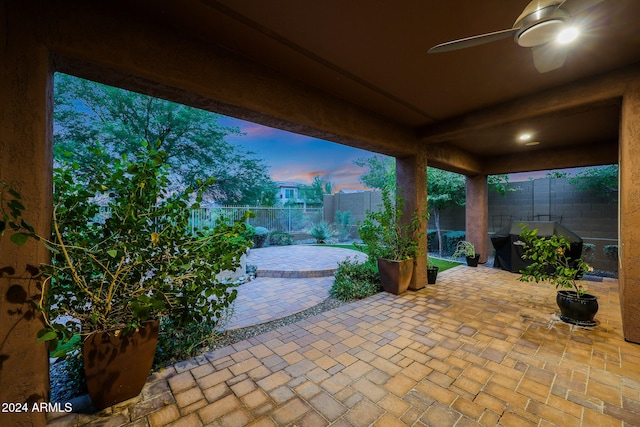 patio terrace at dusk featuring ceiling fan