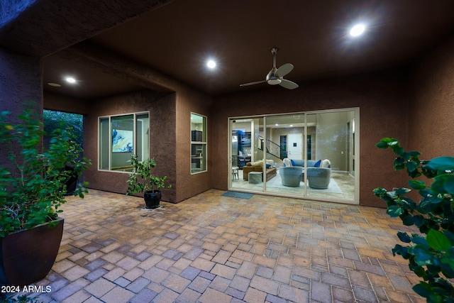 doorway to property with ceiling fan and a patio area