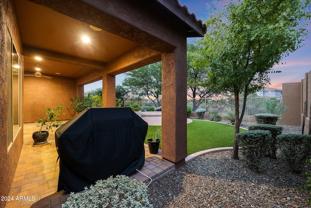 patio terrace at dusk with a grill and a yard