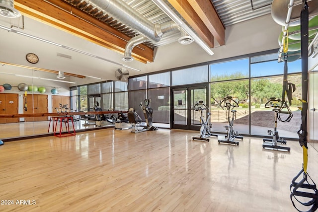 workout area featuring hardwood / wood-style floors and a high ceiling