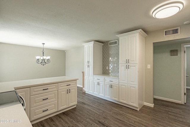 kitchen with dark wood-style floors, visible vents, and light countertops